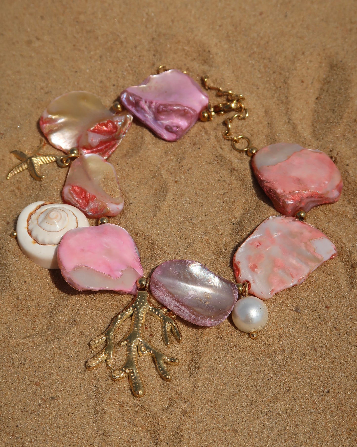 Statement armband van roze schelpen met speelse bedels