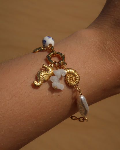 Goude bedelarmband van stainless steel met een zeepaard, schelpen en parels