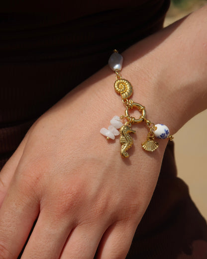 Goude bedelarmband van stainless steel met een zeepaard, schelpen en parels