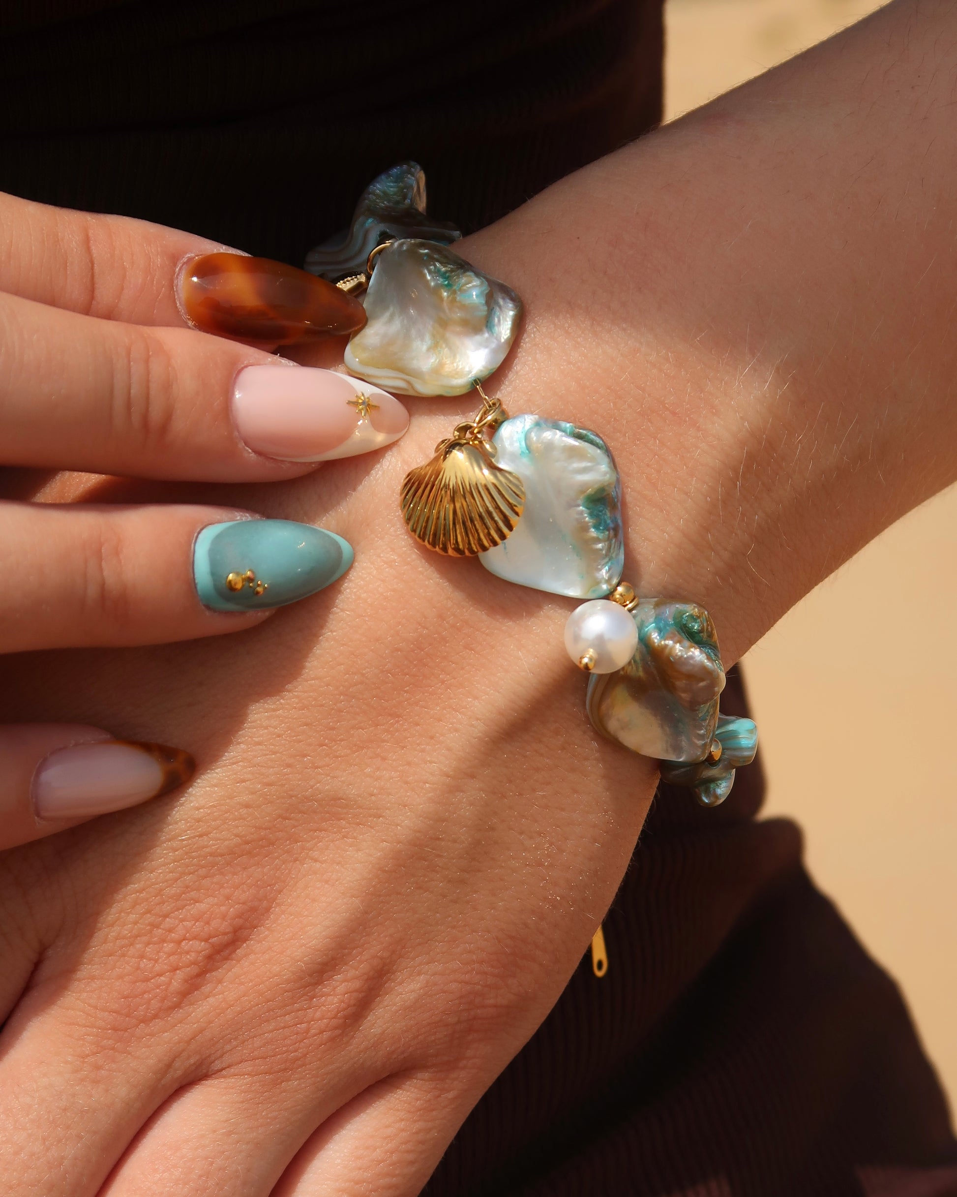 Statement armband van blauwe schelpen met speelse bedels