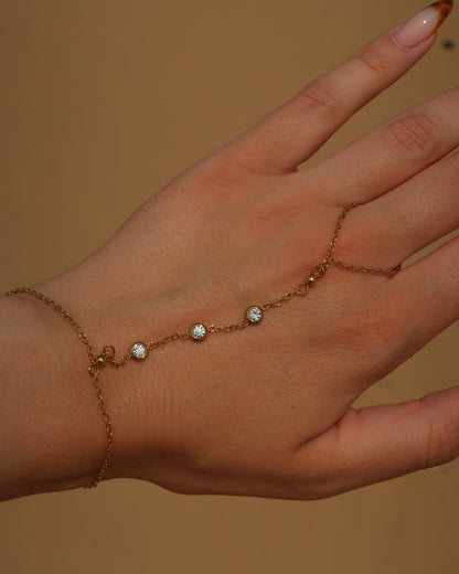 Lume Hand Chain armband voor hand en pols, verkrijgbaar in goud en zilver, stainless steel, waterproof, met drie subtiele steentjes, verstelbaar en ook verkrijgbaar als sieradenset met bijpassende ketting.


