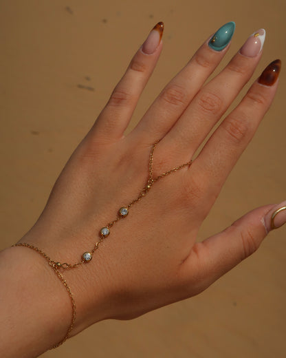 Lume Hand Chain armband voor hand en pols, verkrijgbaar in goud en zilver, stainless steel, waterproof, met drie subtiele steentjes, verstelbaar en ook verkrijgbaar als sieradenset met bijpassende ketting.