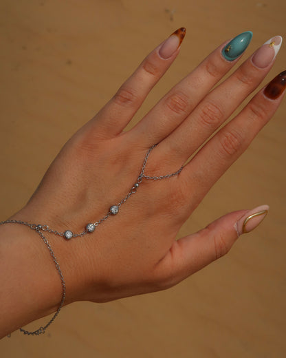 Lume Hand Chain armband voor hand en pols, verkrijgbaar in goud en zilver, stainless steel, waterproof, met drie subtiele steentjes, verstelbaar en ook verkrijgbaar als sieradenset met bijpassende ketting.