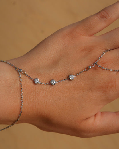 Lume Hand Chain armband voor hand en pols, verkrijgbaar in goud en zilver, stainless steel, waterproof, met drie subtiele steentjes, verstelbaar en ook verkrijgbaar als sieradenset met bijpassende ketting.
