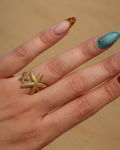 Zanzibar Ring: gouden ring met open design en twee zeesterren. Speelse zomerse look, stainless steel en waterproof.