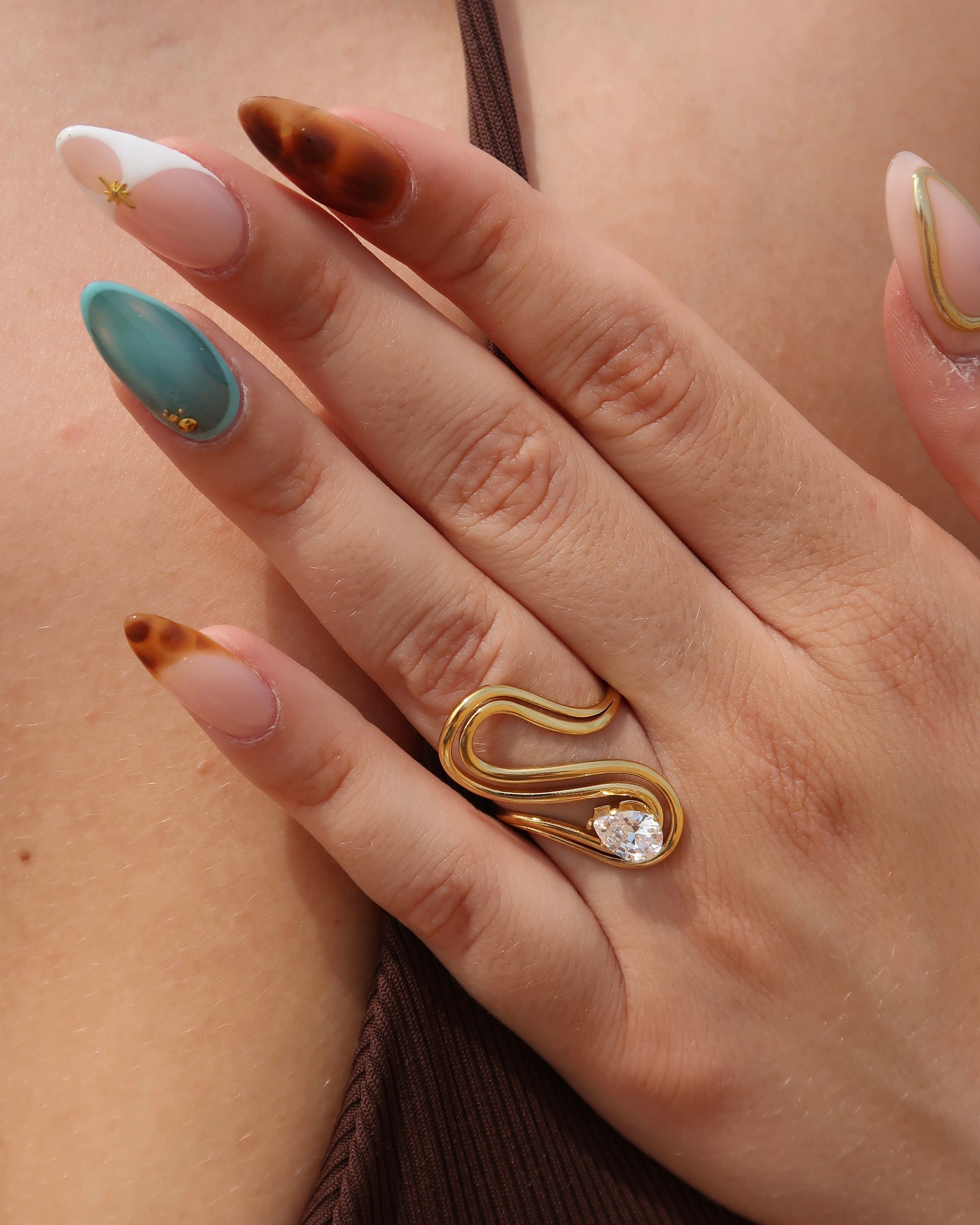 Sway Ring: gouden statement ring met vloeiend design en fonkelende steen. Luxe uitstraling, stainless steel en waterproof.