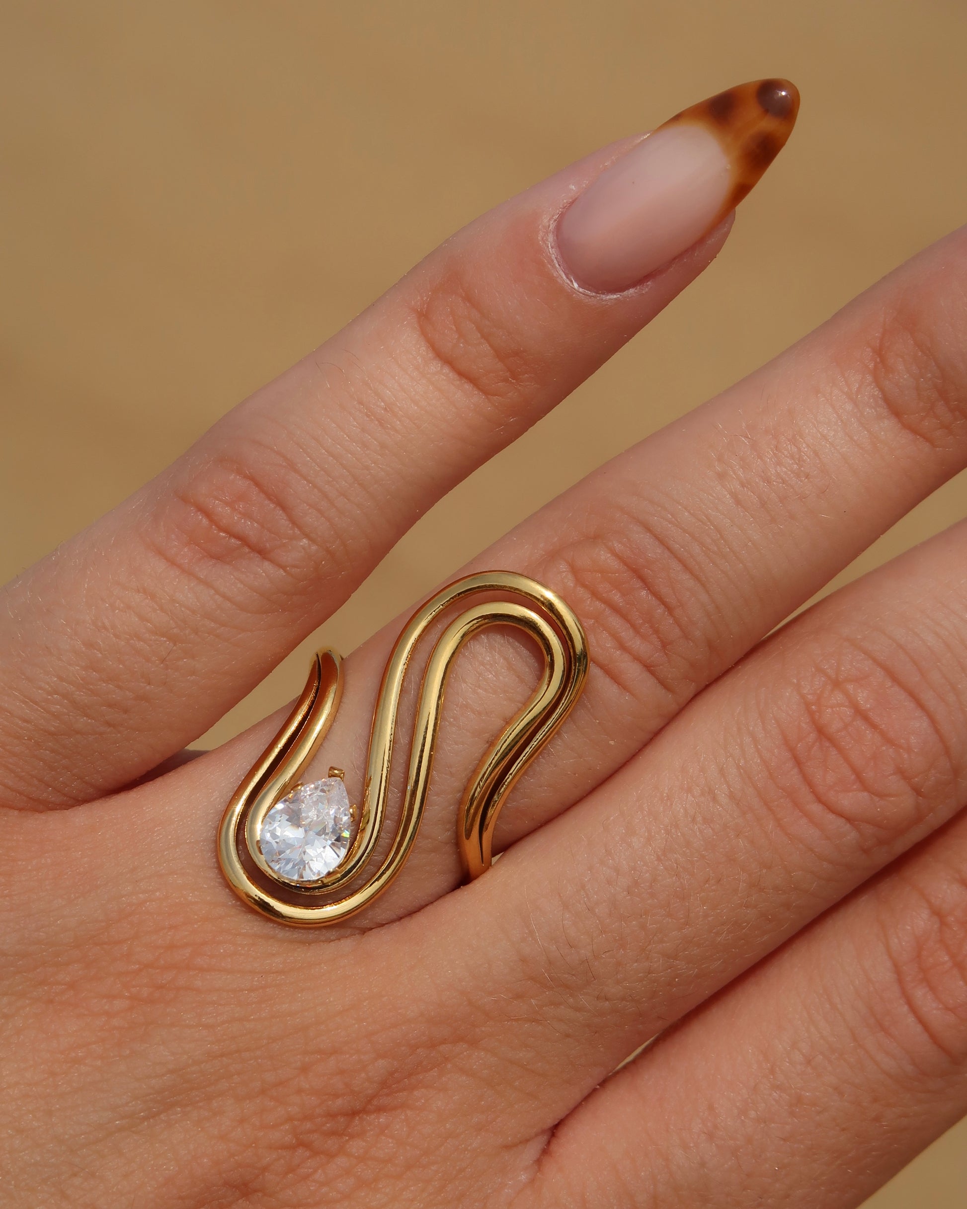 Sway Ring: gouden statement ring met vloeiend design en fonkelende steen. Luxe uitstraling, stainless steel en waterproof.