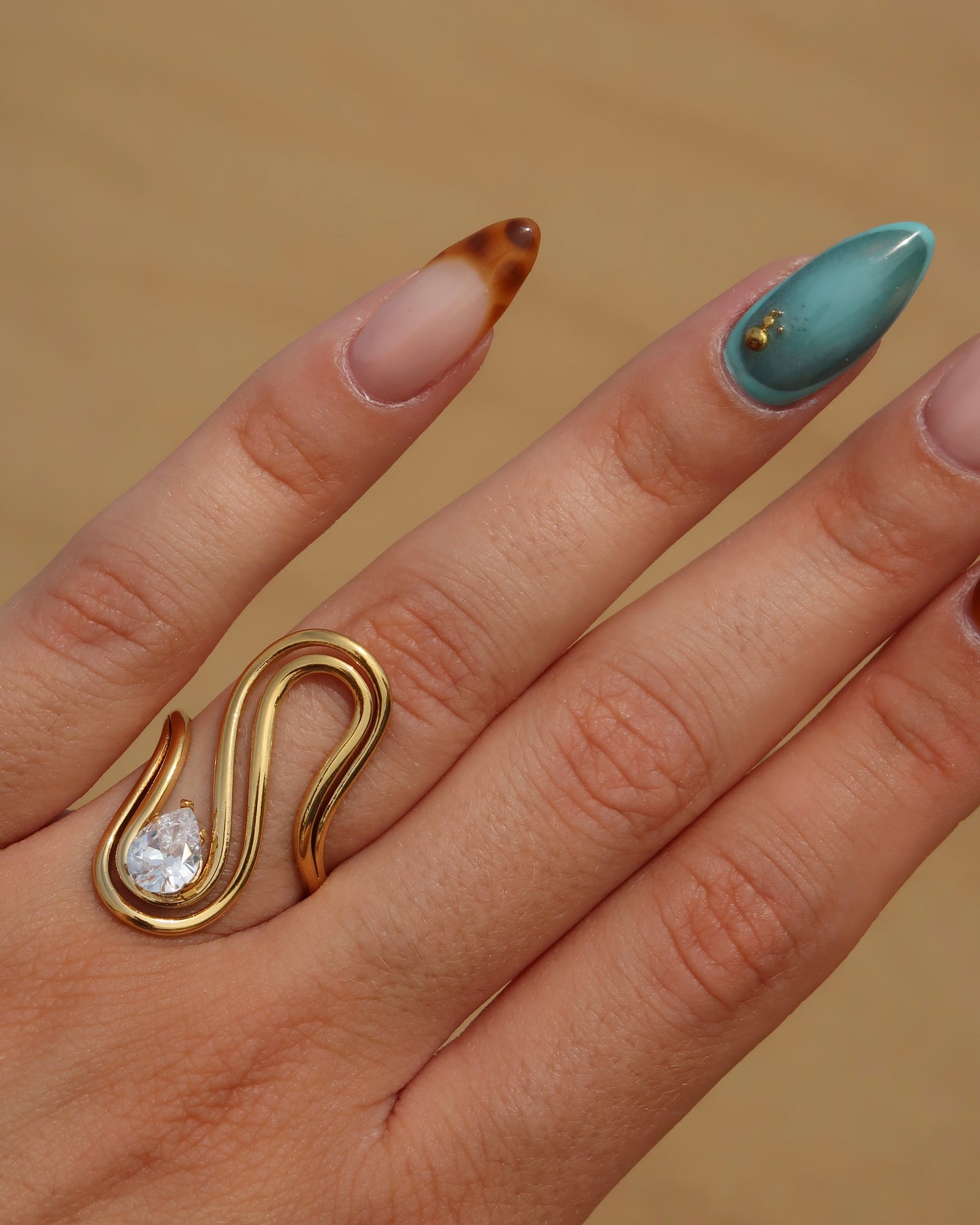 Sway Ring: gouden statement ring met vloeiend design en fonkelende steen. Luxe uitstraling, stainless steel en waterproof.