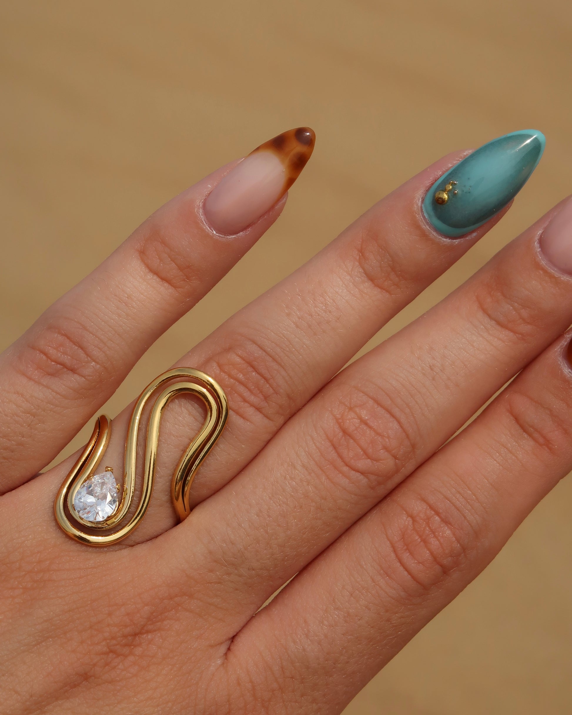 Sway Ring: gouden statement ring met vloeiend design en fonkelende steen. Luxe uitstraling, stainless steel en waterproof.