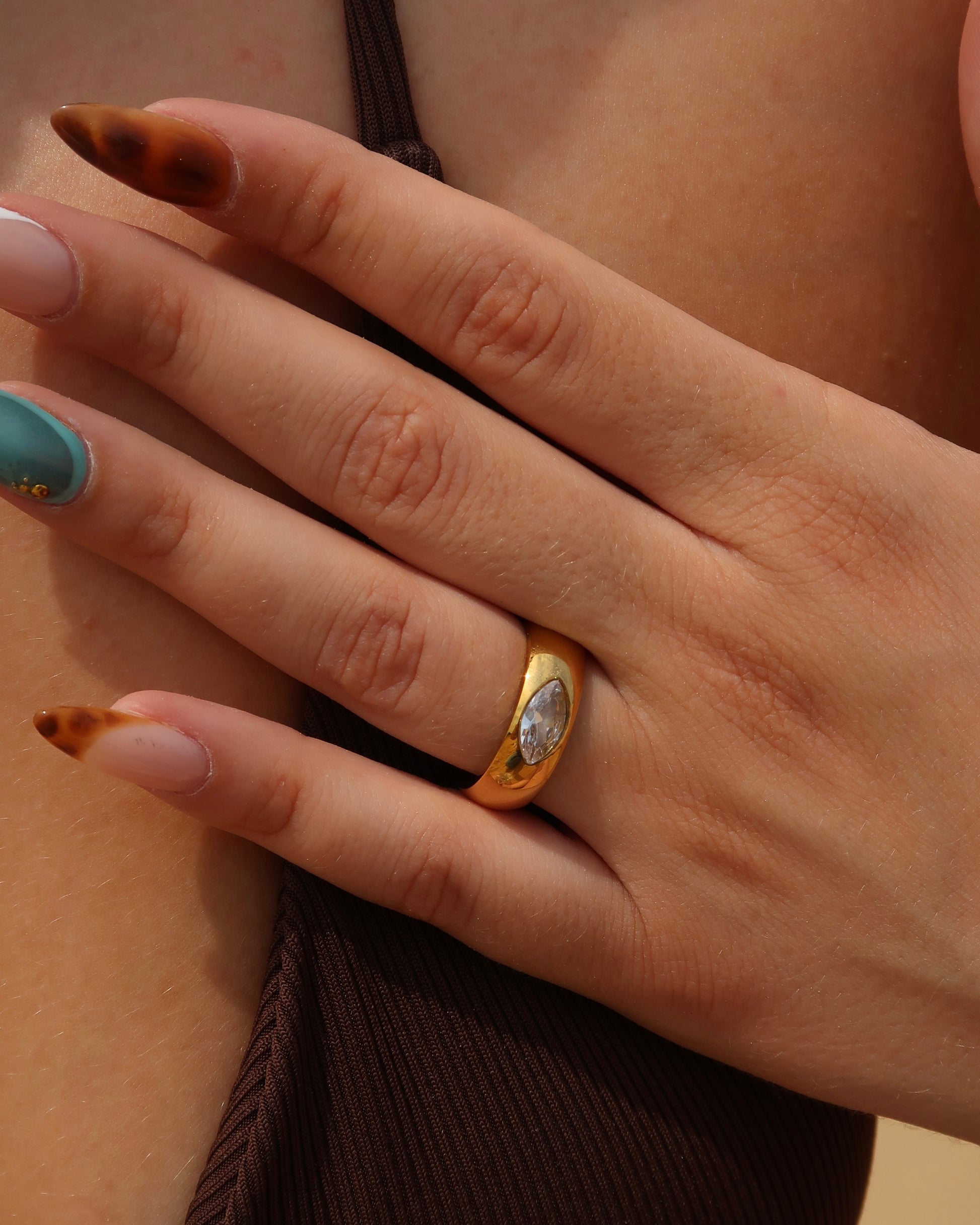 Bandz Ring: gouden ring met subtiele steen. Tijdloos design, solo of gecombineerd te dragen. Stainless steel en waterproof.