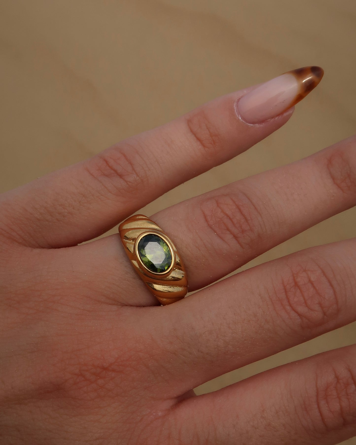 Ember Ring: elegante gouden ring met reliëf en groene steen als eyecatcher. Chique uitstraling, stainless steel en waterproof.