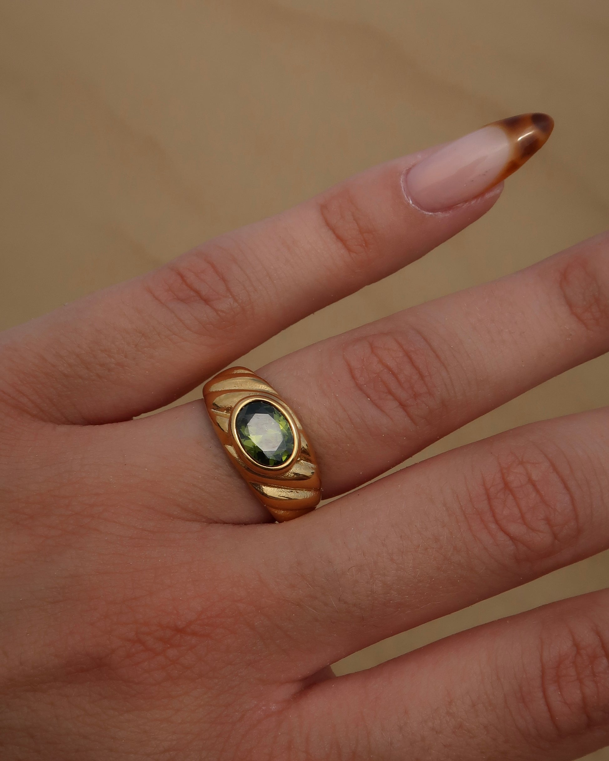 Ember Ring: elegante gouden ring met reliëf en groene steen als eyecatcher. Chique uitstraling, stainless steel en waterproof.