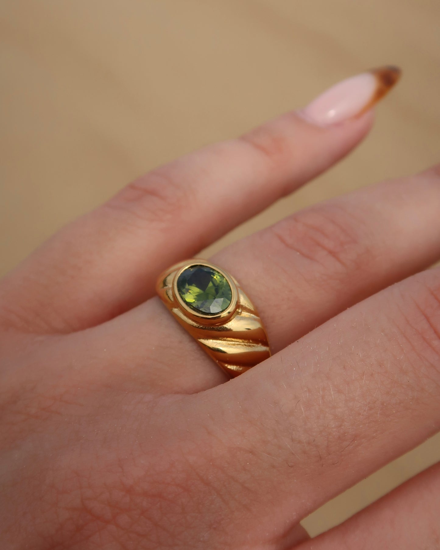 Ember Ring: elegante gouden ring met reliëf en groene steen als eyecatcher. Chique uitstraling, stainless steel en waterproof.