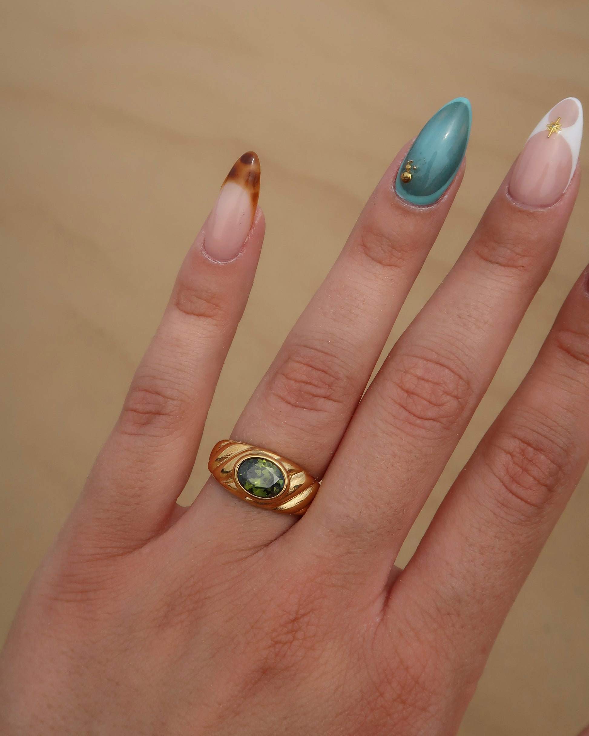 Ember Ring: elegante gouden ring met reliëf en groene steen als eyecatcher. Chique uitstraling, stainless steel en waterproof.