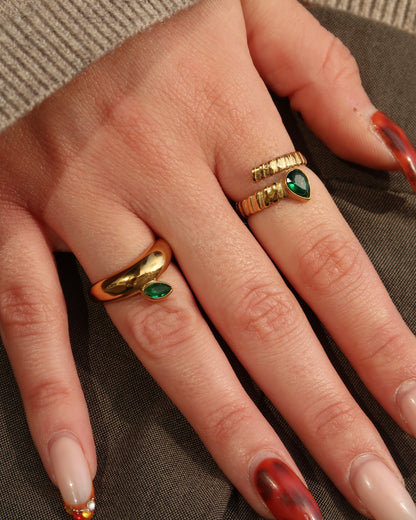 Gouden spiraalvormige ring met reliëf en groene druppelvormige steen aan het uiteinde, gemaakt van stainless steel