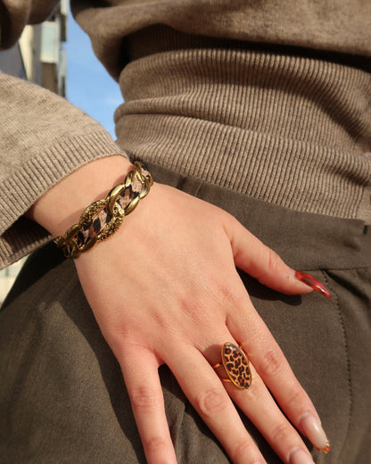 Gouden statement armband met panterprint detail en verstelbare sluiting.
