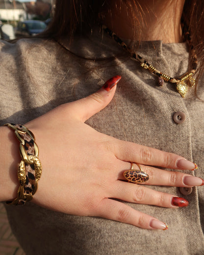 Gouden statement armband met panterprint detail en verstelbare sluiting.