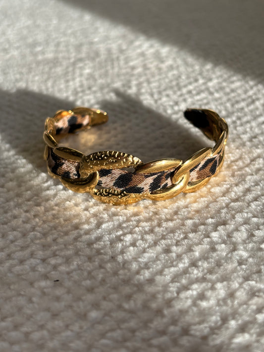 Gouden statement armband met panterprint detail en verstelbare sluiting.