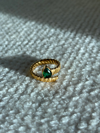 Gouden spiraalvormige ring met reliëf en groene druppelvormige steen aan het uiteinde, gemaakt van stainless steel