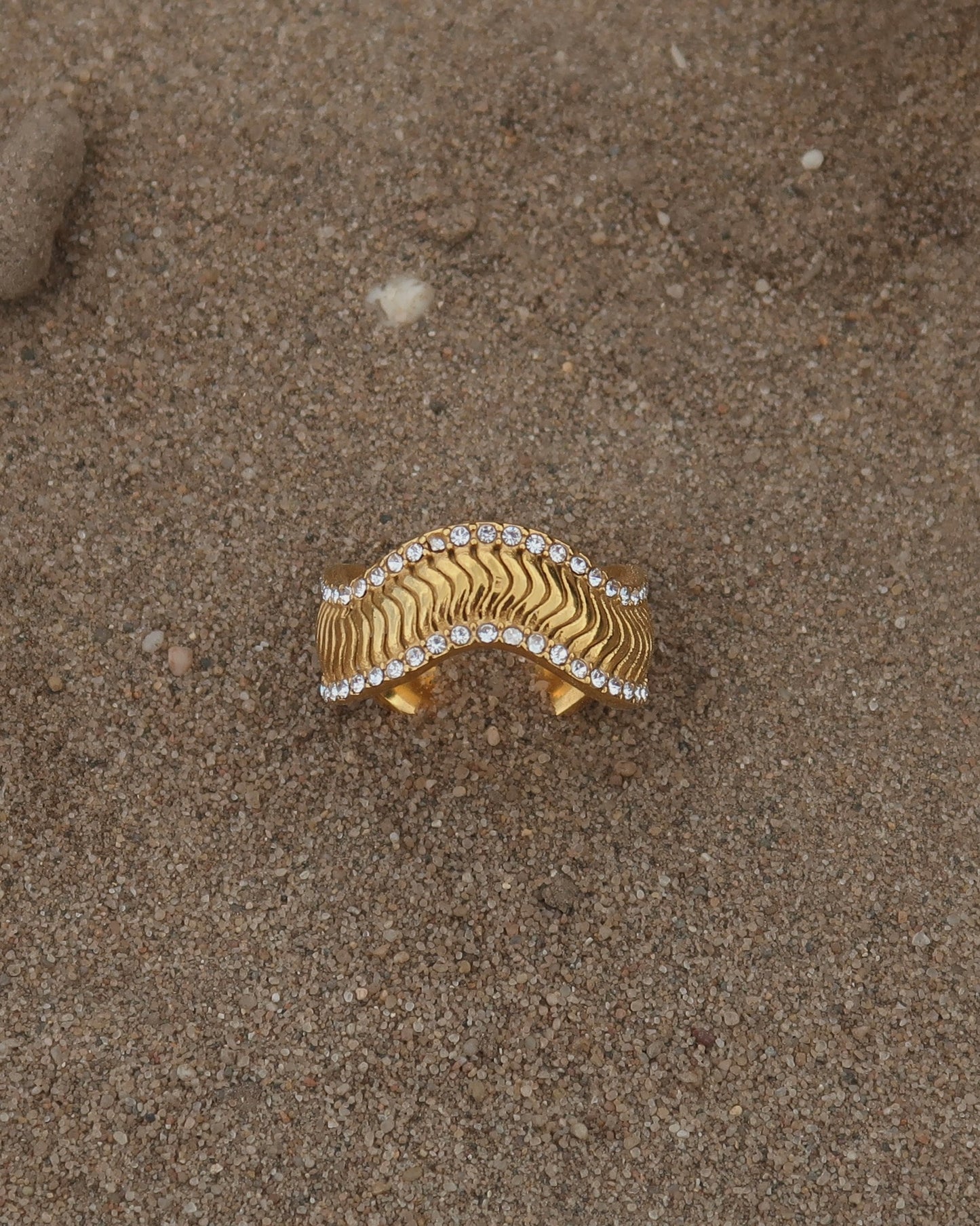 Gouden ring met golvend reliëf en zilverkleurige steentjes langs de randen - gemaakt van stainless steel
