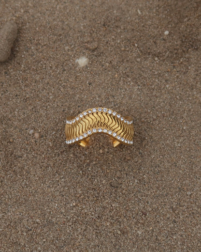 Gouden ring met golvend reliëf en zilverkleurige steentjes langs de randen - gemaakt van stainless steel
