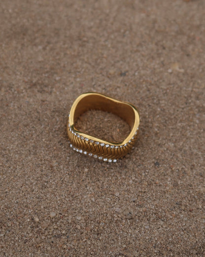 Gouden ring met golvend reliëf en zilverkleurige steentjes langs de randen - gemaakt van stainless steel