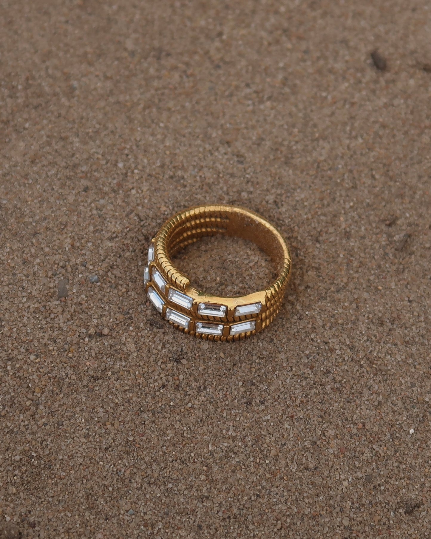 Goudkleurige statement ring met twee rijen zilveren steentjes en verfijnde details – waterproof en stainless steel.