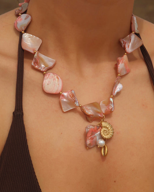 Statement ketting van roze schelpen met gouden hangers, waaronder schelpen