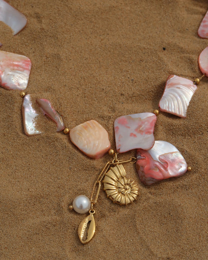 Statement ketting van roze schelpen met gouden hangers, waaronder schelpen