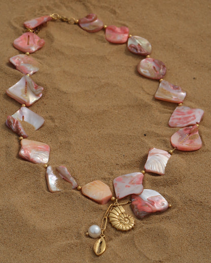 Statement ketting van roze schelpen met gouden hangers, waaronder schelpen