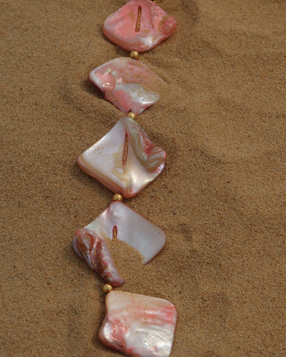 Statement ketting van roze schelpen met gouden hangers, waaronder schelpen